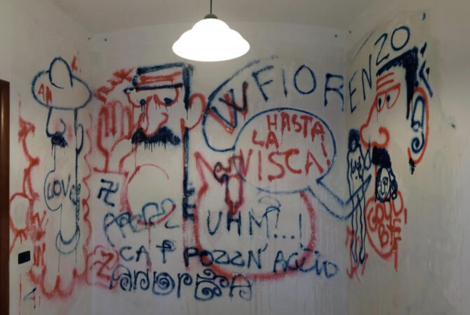 Disegni di un inedito Paz Disegni, realizzati con bombolette spray blu e rosso sulle pareti della casa delle vacanze a San Menaio